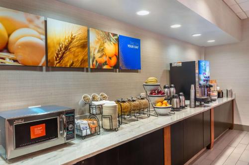 a breakfast counter in a hotel room with a microwave at Comfort Inn & Suites Logan International Airport in Revere