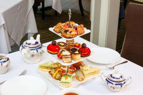 a table topped with three tiers of sandwiches and pastries at The Peacock Inn, an Ascend Collection Hotel in Princeton