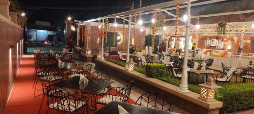 a restaurant with tables and chairs and lights at Hotel The Balam in Jodhpur