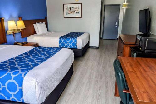 a hotel room with two beds and a flat screen tv at Baymont by Wyndham Hannibal in Hannibal