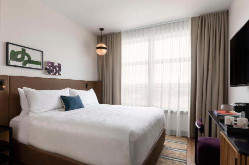 a hotel room with a bed and a large window at Kissel Uptown Oakland, in the Unbound Collection by Hyatt in Oakland