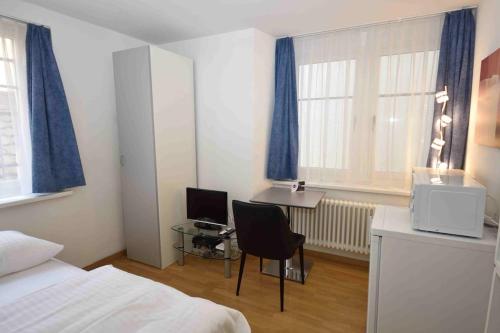 a bedroom with a bed and a desk with a computer at Room in famous area - Stork 31 in Zürich