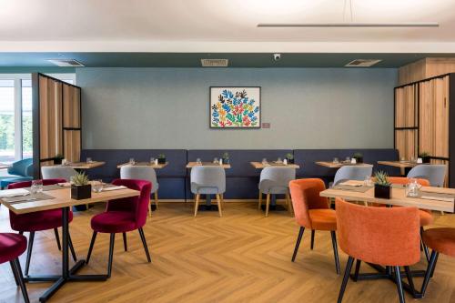 a dining room with tables and chairs at Hilton Garden Inn Milan Malpensa in Somma Lombardo