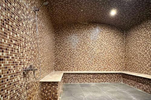 a bathroom with a shower with a brick wall at Ramada by Wyndham Gaziantep in Gaziantep