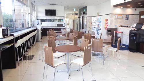 un ristorante con tavoli e sedie e una cucina di Toyoko Inn Tokushima Ekimae a Tokushima