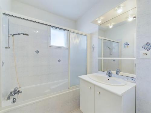 une salle de bain blanche avec un lavabo et une douche dans l'établissement Appartement pour 4 personnes aux Sables d'Olonnes, à Les Sables-dʼOlonne