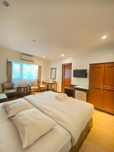 a bedroom with a large bed and a living room at Cipta Hotel Wahid Hasyim in Jakarta