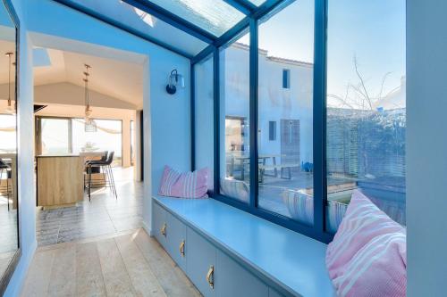 Cette chambre est dotée de murs bleus et de grandes fenêtres. dans l'établissement 6 adultes et 2 enfants - piscine et accès plage direct, à La Guérinière