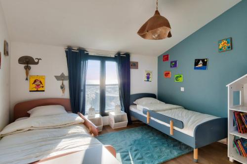 two twin beds in a room with a window at 6 adultes et 2 enfants - piscine et accès plage direct in La Guérinière
