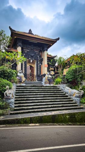 a building with stairs and statues in front of it at Puri Karang Residence in Bangli