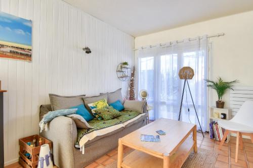 ein Wohnzimmer mit Sofa und Tisch in der Unterkunft À 300m de la plage, maison pour 6 personnes in La Guérinière