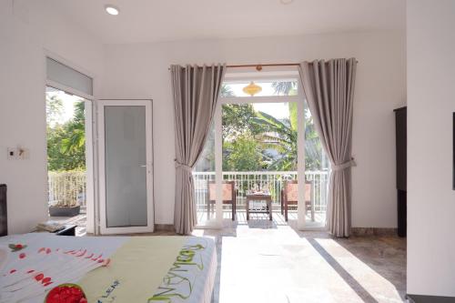 a bedroom with a bed and a sliding glass door at Lucky Leaf Hoian Villa in Hoi An