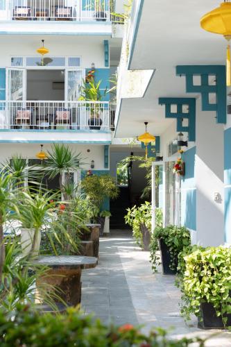 a corridor of a building with plants and benches at Lucky Leaf Hoian Villa in Hoi An