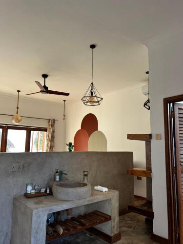 ein Bad mit einem Waschbecken und einem Deckenventilator in der Unterkunft Zanzi Soul Luxury Boutique Hotel in Jambiani