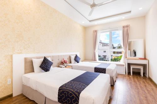 a bedroom with two beds and a window at Saigon's Book Da Lat Hotel in Da Lat