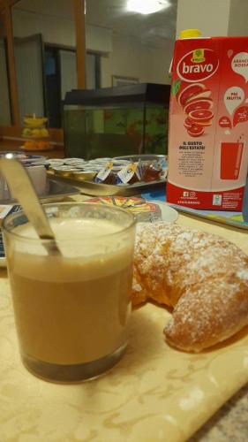 a plate of food with a drink and a doughnut at Hotel Residence La Fontana in Mariano Comense
