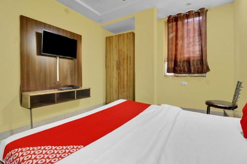 a bedroom with a large bed with a tv on the wall at OYO 82518 hotel Royal in in Gwalior