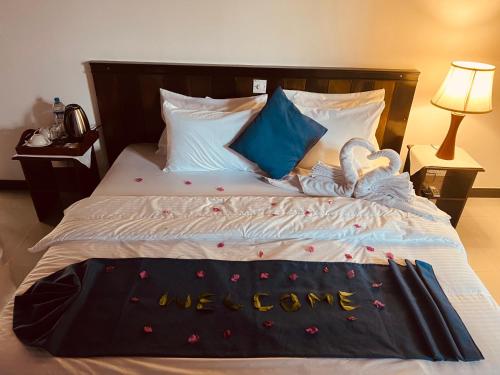 a bed with a we came sign on it at Kingz Kottage in Negombo