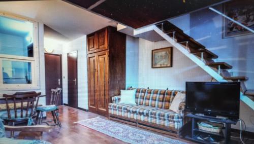 a living room with a couch and a staircase at casa vacanze Mario in San Massimo