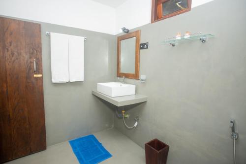 a bathroom with a sink and a mirror at Olive Villa in Galle