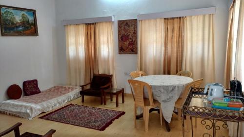 a living room with a table and a bedroom at Jheelam Homestay in Bhopal