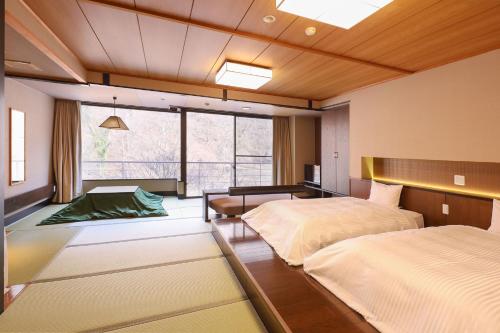 a bedroom with two beds and a large window at TAOYA Kawaji in Nikko