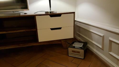 a room with a desk with a tv and a drawer at Basel Charme Apartments in Basel