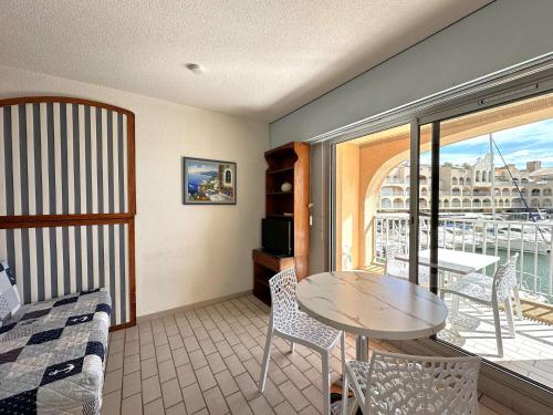 d'un salon avec une table et un balcon. dans l'établissement HYEDHI Studio pour 4 personnes avec vue mer sur le port d'Hyères, à Hyères