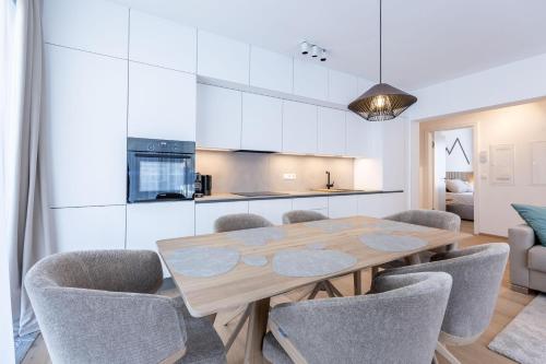 a kitchen and dining room with a wooden table and chairs at Alpine Suite Spot in Bad Mitterndorf