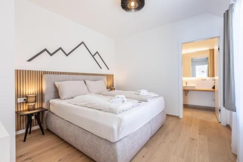 a bedroom with a large white bed with a mountain headboard at Alpine Suite Spot in Bad Mitterndorf