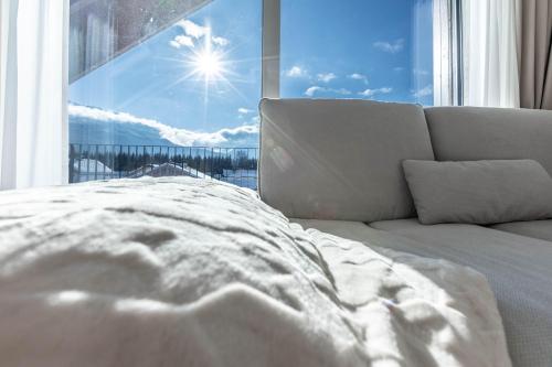 a bed in front of a window with a view at Alpine Suite Spot in Bad Mitterndorf