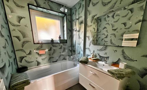 une salle de bain avec une baignoire, un lavabo et un miroir dans l'établissement La Vue Sur Mer - Appart avec place de parking, à Boulogne-sur-Mer