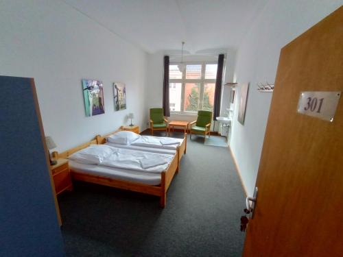 a bedroom with a bed and a table and chairs at Die Fabrik - Hostel in Berlin