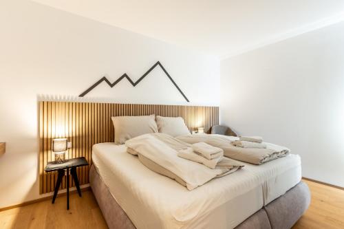 a bedroom with a large bed with a mountain sign on the wall at Alpine Suite Spot in Bad Mitterndorf