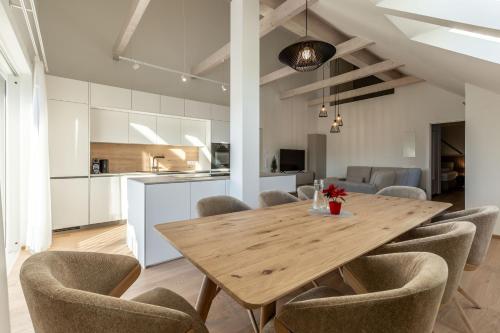 a kitchen and dining room with a wooden table and chairs at Alpine Suite Spot in Bad Mitterndorf