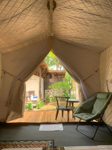 a room with a tent with a chair and a patio at Long Hải Channel Beach Resort in Long Hai