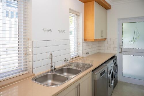 a kitchen with a sink and a washing machine at Thesen Island Villas in Knysna