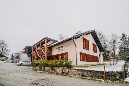 a building on a street with a car parked next to it at Apartments Maleric with Indoor Pool and Wellness in Dragatuš
