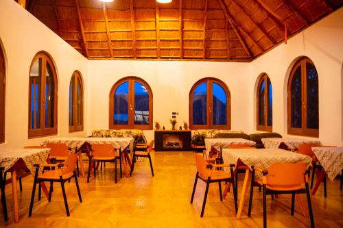 a large room with tables and chairs and windows at Tabebuia Spa and Safari Resort in Fort Portal