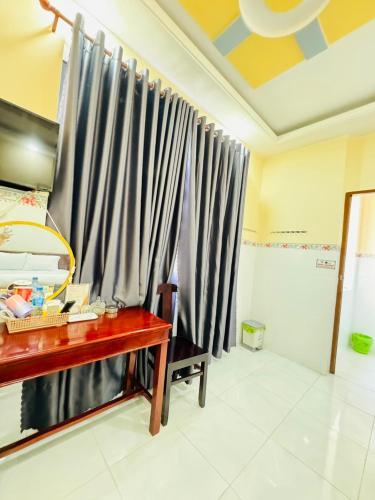 a room with a desk and a curtain at NHÀ NGHỈ THANH XUÂN- Có cho thuê xe máy và xuất hóa đơn in Ấp Ðông An (1)