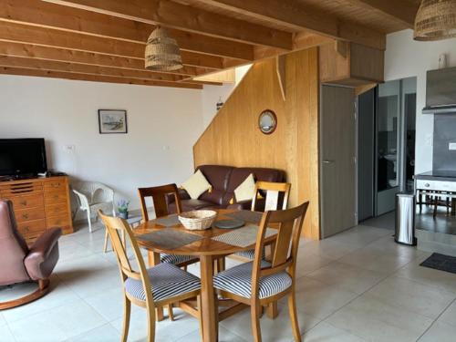 une table à manger et des chaises dans un salon dans l'établissement les gites du corsen, à Plouarzel