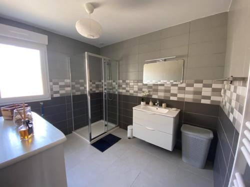 une salle de bain avec une douche, un lavabo et un miroir dans l'établissement les gites du corsen, à Plouarzel