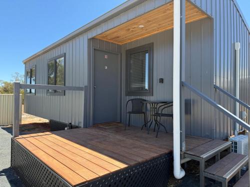 a deck with a table and chairs on a house at Woomelang Cabin Silo Trail Two Bedroom Cabin Queen and KSing in Woomelang
