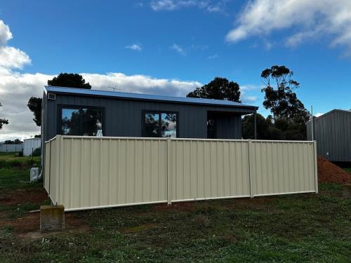 a house with a white fence in front of it at Woomelang Cabin Silo Trail Two Bedroom Cabin Queen and KSing in Woomelang