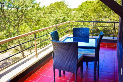 a table and chairs on a balcony with trees at BATIAN APARTMENT WITHIN MT.KENYA WILDLIFE ESTATE AT OL PEJETA in Ol Pejeta Conservancy