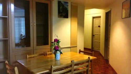 a dining room table with a vase of flowers on it at Star Regency 2 Rooms Apt, Brinchang Town in Cameron Highlands