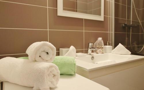 La salle de bains est pourvue de serviettes sur le comptoir et d'un lavabo. dans l'établissement T2 avec piscine à Anglet Golf de Biarritz, à Anglet