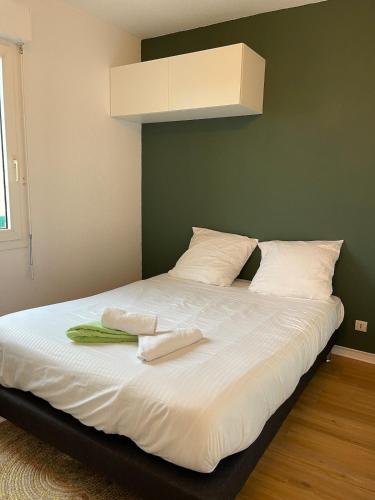 un lit avec deux serviettes dessus dans l'établissement T2 avec piscine à Anglet Golf de Biarritz, à Anglet