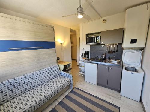un salon avec un canapé et une cuisine dans l'établissement Studio moderne au calme, piscine dans la résidence, lave linge, à Saint-Mandrier-sur-Mer