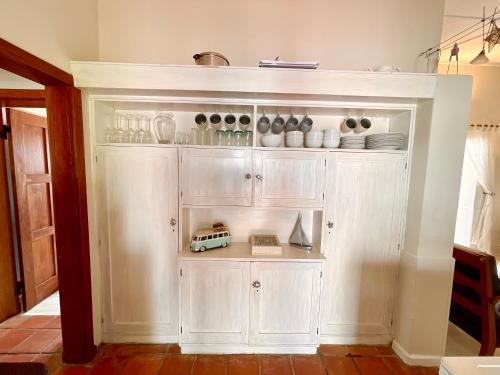 una choza blanca con platos y tazones. en Sashalon Beachfront Cottage, en Swakopmund
